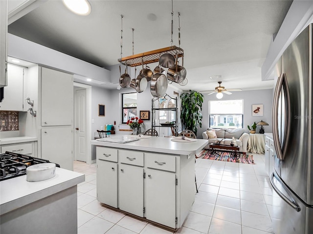 kitchen with white cabinetry, ceiling fan, stainless steel fridge, and light tile patterned floors