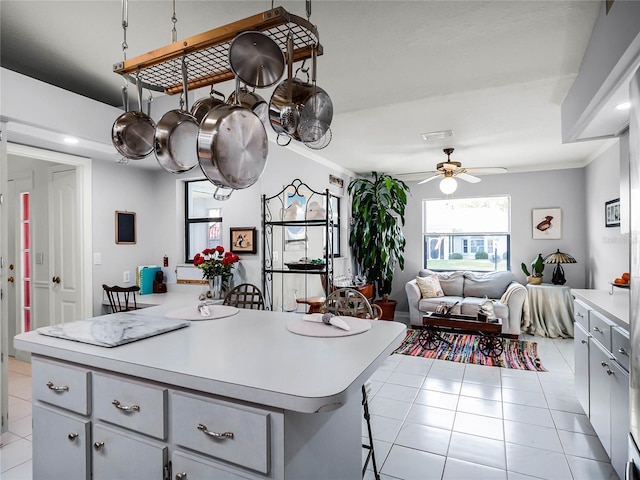 kitchen featuring light tile patterned floors, crown molding, a breakfast bar, and a kitchen island