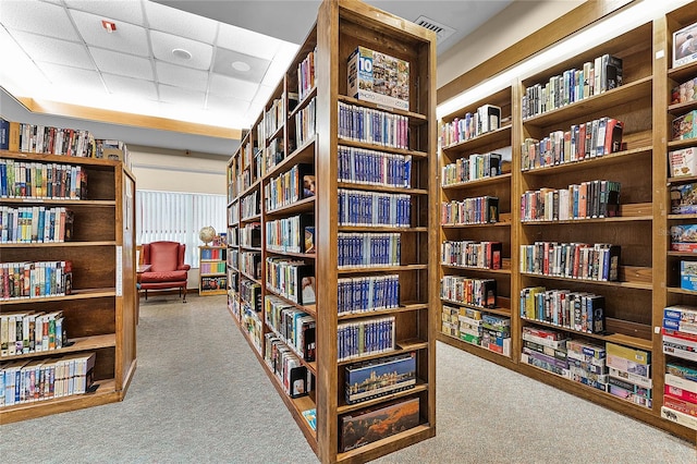 interior space with a paneled ceiling and carpet