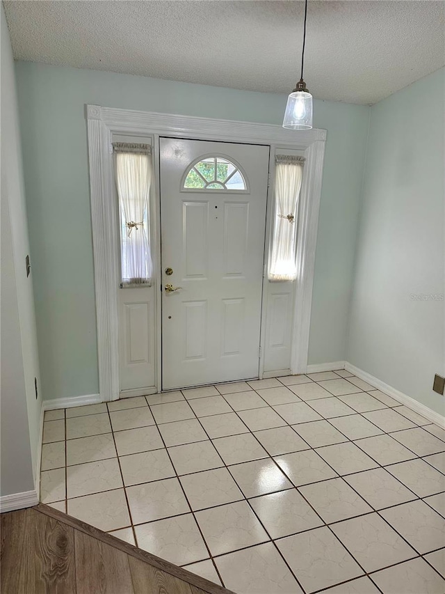 tiled foyer entrance featuring a textured ceiling