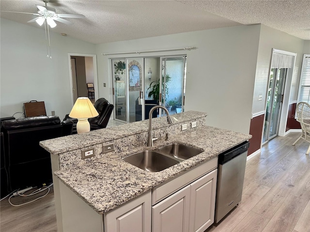 kitchen featuring sink, a kitchen island with sink, white cabinets, a textured ceiling, and stainless steel dishwasher