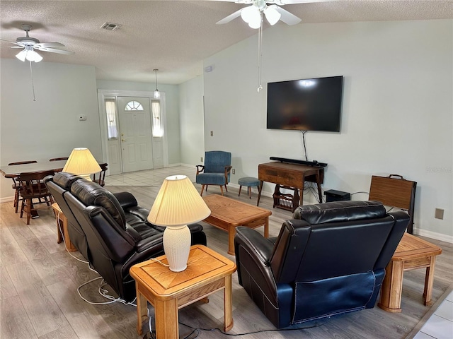 living room with hardwood / wood-style flooring, ceiling fan, and a textured ceiling