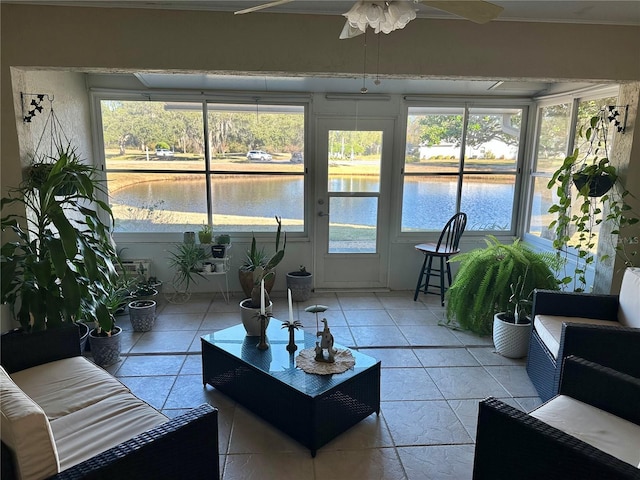 sunroom featuring ceiling fan and a water view