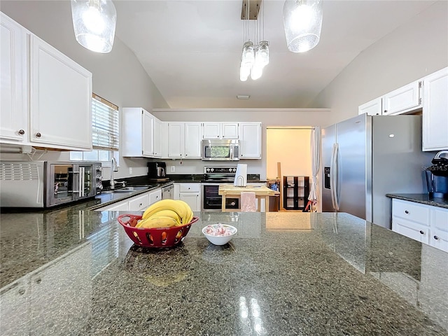 kitchen featuring sink, hanging light fixtures, dark stone countertops, appliances with stainless steel finishes, and white cabinets