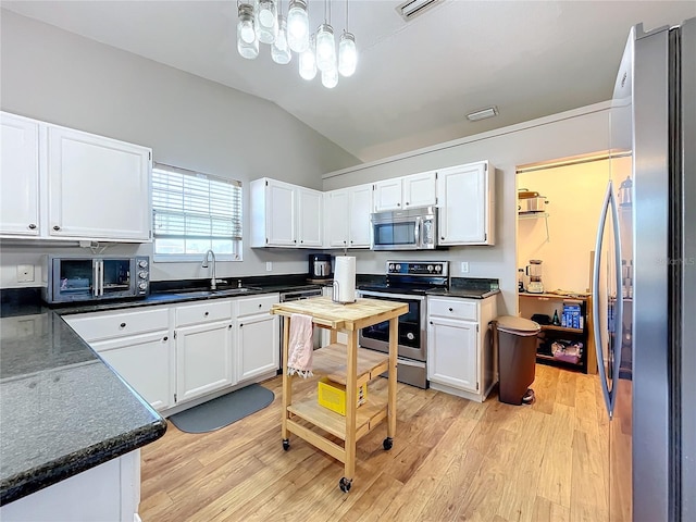 kitchen with stainless steel appliances, decorative light fixtures, light hardwood / wood-style floors, and white cabinets