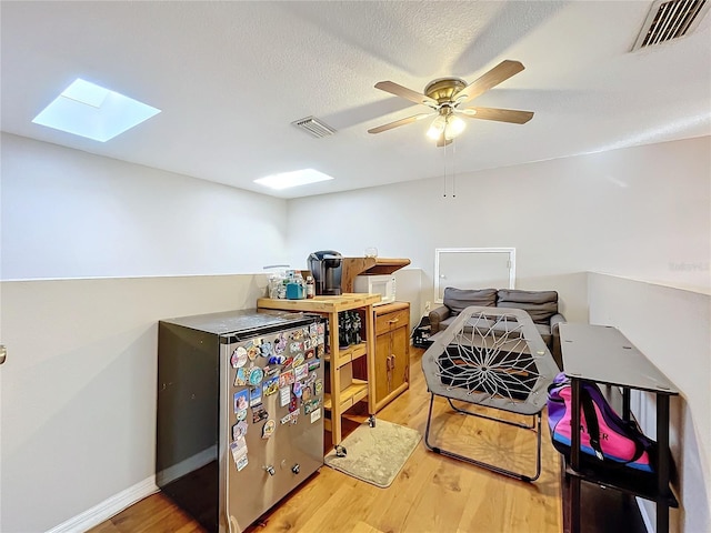 interior space featuring ceiling fan, hardwood / wood-style flooring, and a textured ceiling