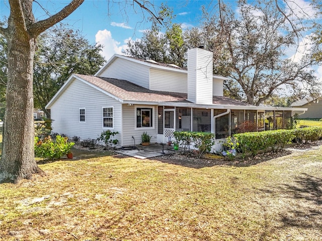 view of front facade with a sunroom, a front yard, and a patio area