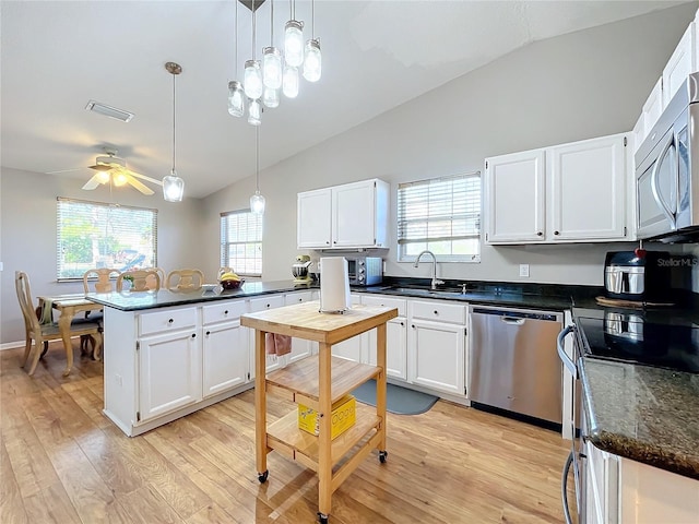 kitchen with hanging light fixtures, stainless steel appliances, sink, and white cabinets