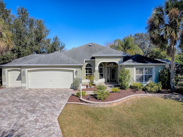 ranch-style home with a garage and a front lawn