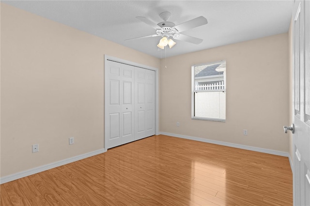 unfurnished bedroom featuring light hardwood / wood-style floors, ceiling fan, and a closet