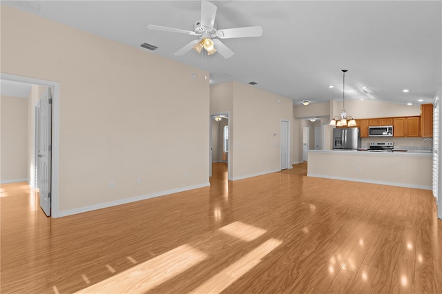 unfurnished living room with ceiling fan, lofted ceiling, sink, and light wood-type flooring