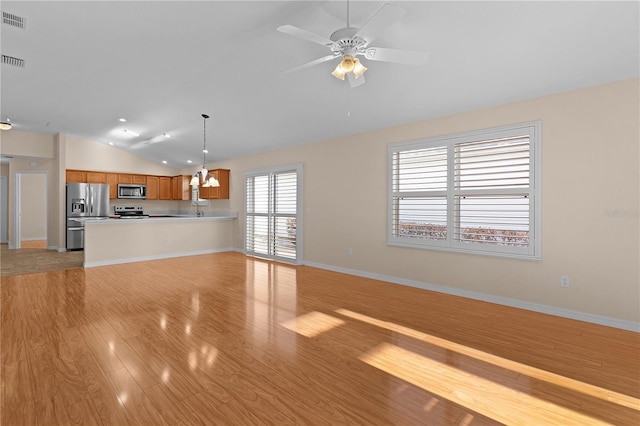 unfurnished living room featuring vaulted ceiling, ceiling fan with notable chandelier, and light hardwood / wood-style flooring