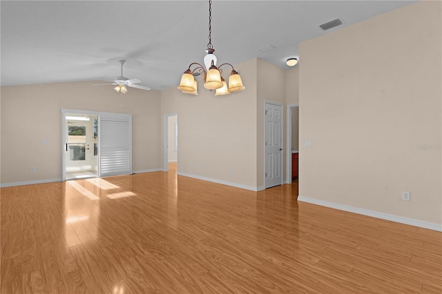 empty room featuring ceiling fan with notable chandelier, lofted ceiling, and light hardwood / wood-style floors