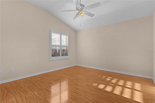 spare room with vaulted ceiling, ceiling fan, and light wood-type flooring