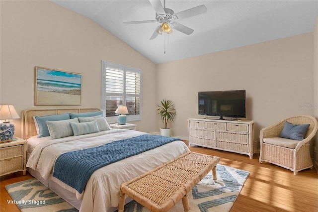 bedroom with hardwood / wood-style flooring, ceiling fan, and vaulted ceiling