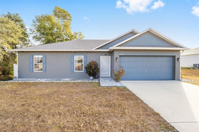 single story home with a garage, a front yard, and central air condition unit