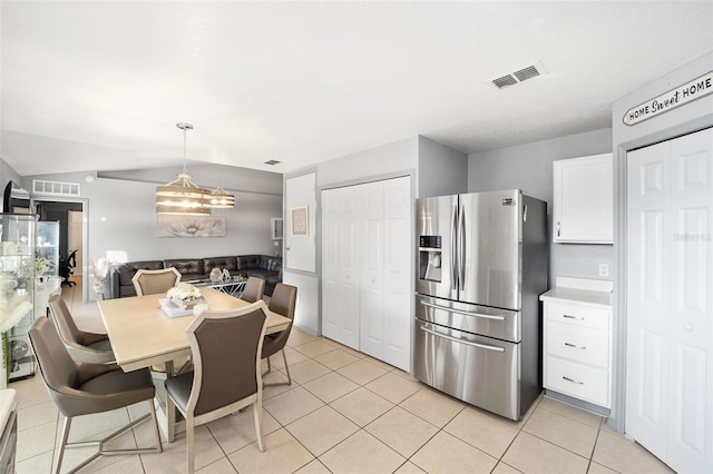 kitchen featuring white cabinetry, stainless steel fridge with ice dispenser, decorative light fixtures, and light tile patterned floors