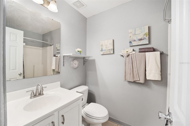 bathroom with vanity, toilet, and a shower