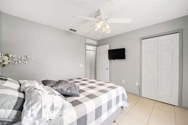 tiled bedroom featuring ceiling fan and a closet