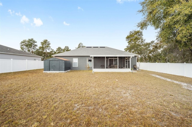 rear view of house with a sunroom and a lawn