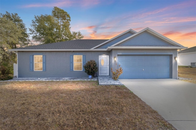 ranch-style house with a garage, a lawn, and central AC