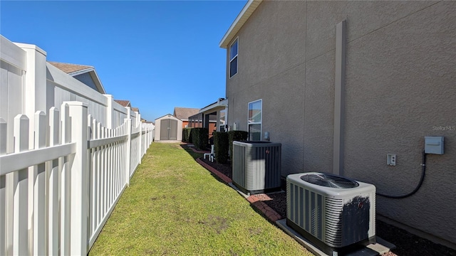 view of yard with central AC and a storage unit