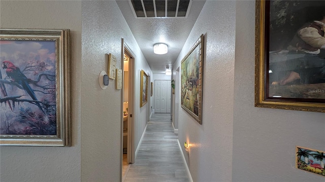 hall featuring hardwood / wood-style flooring and a textured ceiling