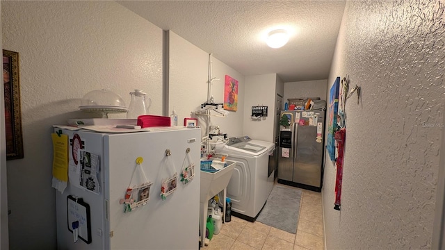 washroom featuring washer and dryer, a textured ceiling, and light tile patterned flooring