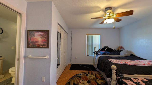 bedroom with hardwood / wood-style flooring, ensuite bath, a closet, and ceiling fan