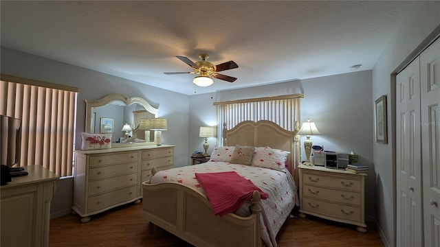 bedroom featuring a textured ceiling, dark wood-type flooring, a closet, and ceiling fan