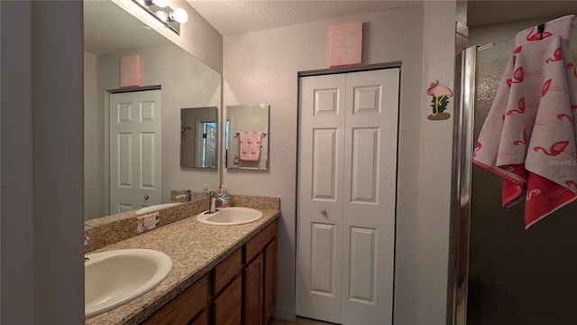 bathroom featuring vanity, an enclosed shower, and a textured ceiling