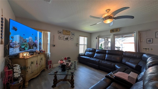 living room featuring ceiling fan, hardwood / wood-style flooring, and a textured ceiling