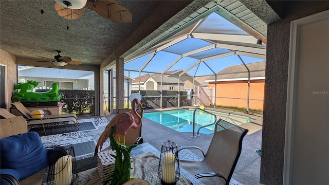 view of swimming pool with a lanai, a patio area, and ceiling fan