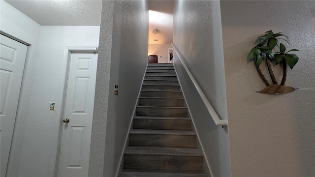 stairs featuring a textured ceiling