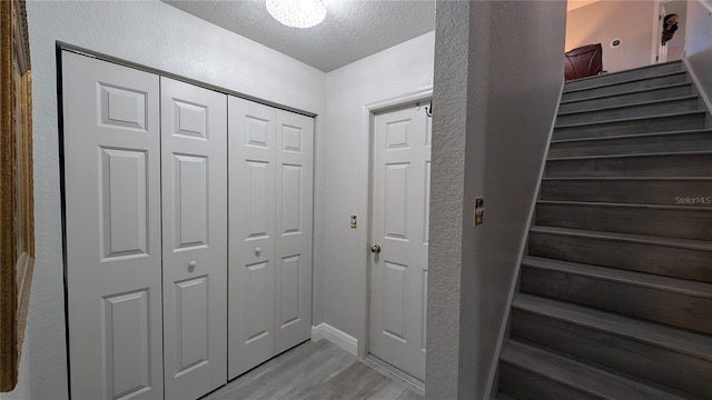 corridor with hardwood / wood-style flooring and a textured ceiling