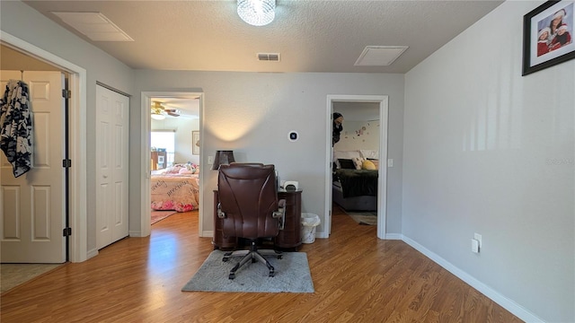 office area featuring a textured ceiling and light hardwood / wood-style flooring