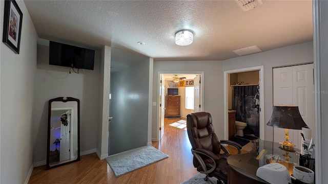 office with hardwood / wood-style flooring and a textured ceiling