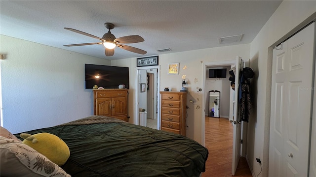 bedroom featuring a textured ceiling, ceiling fan, and light hardwood / wood-style flooring