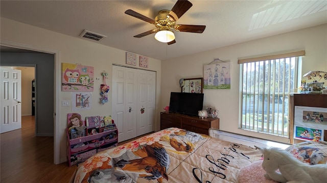 bedroom featuring dark hardwood / wood-style flooring, a textured ceiling, a closet, and ceiling fan