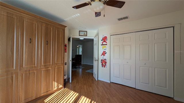 unfurnished bedroom featuring wood-type flooring, ceiling fan, and a closet