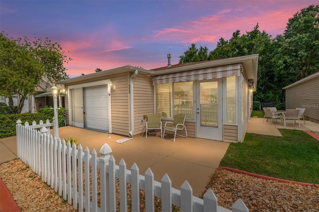 view of front of house featuring a garage and a patio