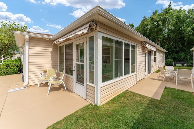 view of side of property with a yard and a patio