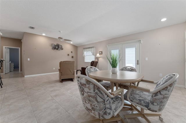 tiled dining area with ceiling fan, a healthy amount of sunlight, and a textured ceiling