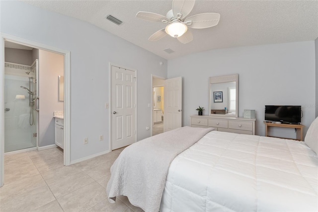 tiled bedroom featuring ceiling fan, ensuite bathroom, and a textured ceiling