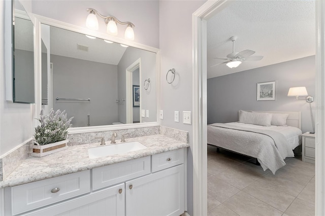 bathroom with ceiling fan, tile patterned flooring, vanity, a textured ceiling, and vaulted ceiling