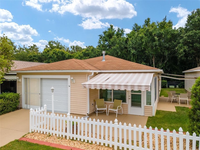 view of front facade featuring a garage and a patio area