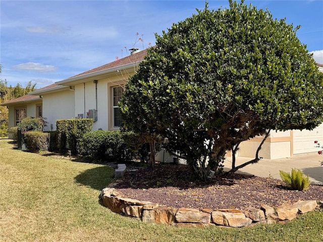 view of home's exterior with a garage and a lawn