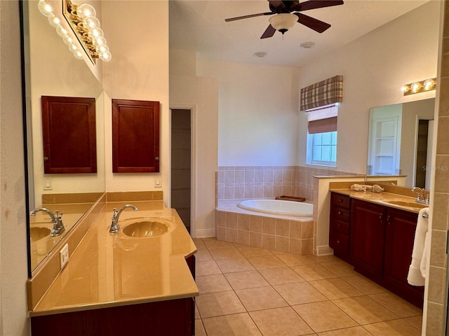 bathroom with tiled tub, vanity, tile patterned floors, and ceiling fan