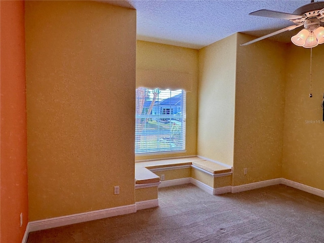 carpeted empty room with ceiling fan and a textured ceiling