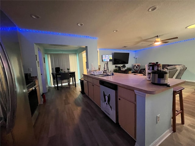 kitchen featuring sink, appliances with stainless steel finishes, dark hardwood / wood-style floors, a kitchen breakfast bar, and ceiling fan